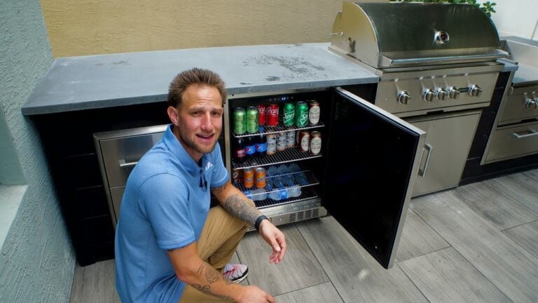 an outdoor kitchen designer in front of a coyote 24 inch refrigerator