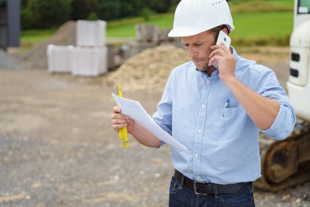 contractor reviewing papers on job site