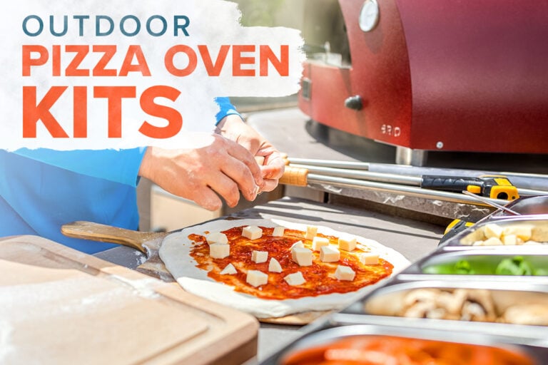 man topping pizza with cheese next to outdoor pizza oven