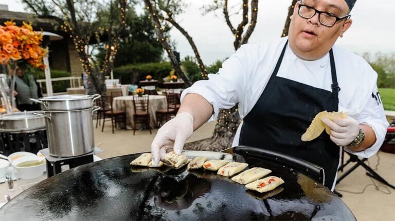 person cooking on evo flat top grill