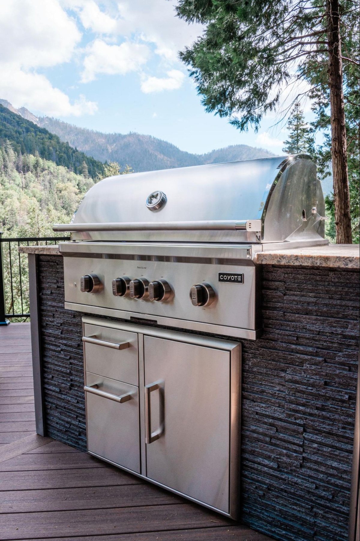 close up of modern stone outdoor kitchen with gas grill