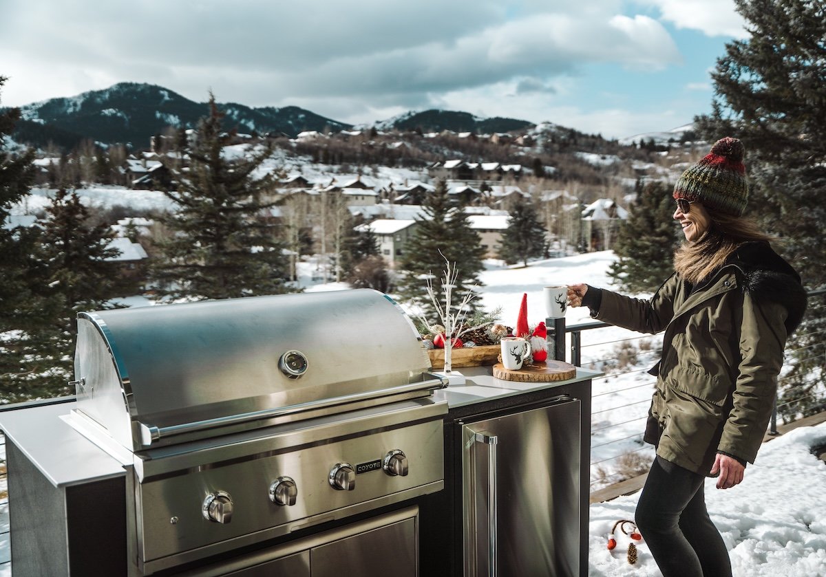 woman enjoying outdoor kitchen in snowy climate