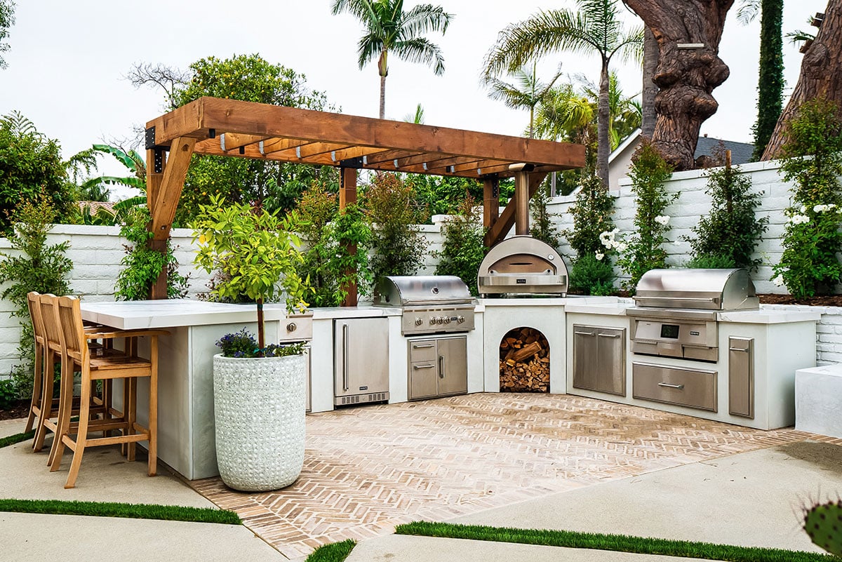 bright stucco modern concrete outdoor kitchen on brick patio