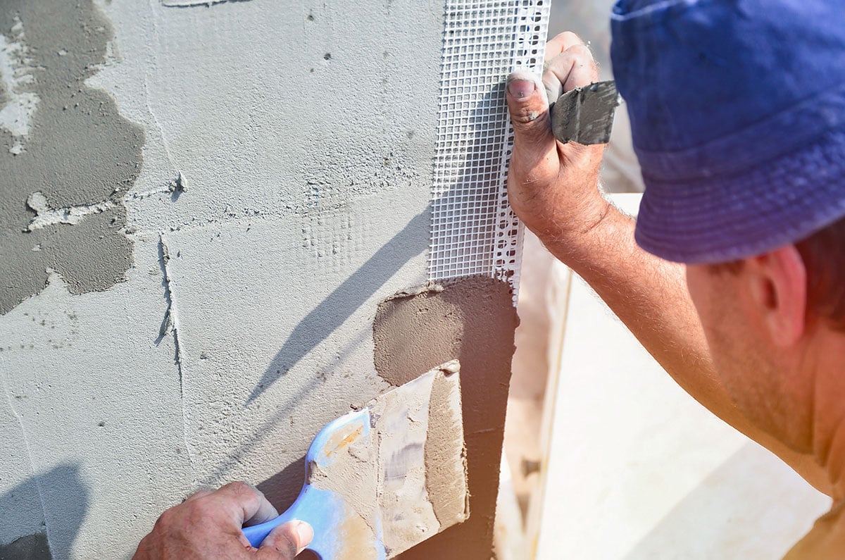 man applying mesh to an outdoor kitchen