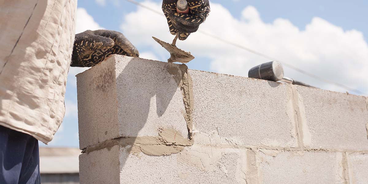 man building labor-intensive cinder block outdoor kitchen